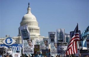 Demonstrators hold up signs during "Stop Watching Us: A Rally Against Mass Surveillance" march near U.S. Capitol in Washington